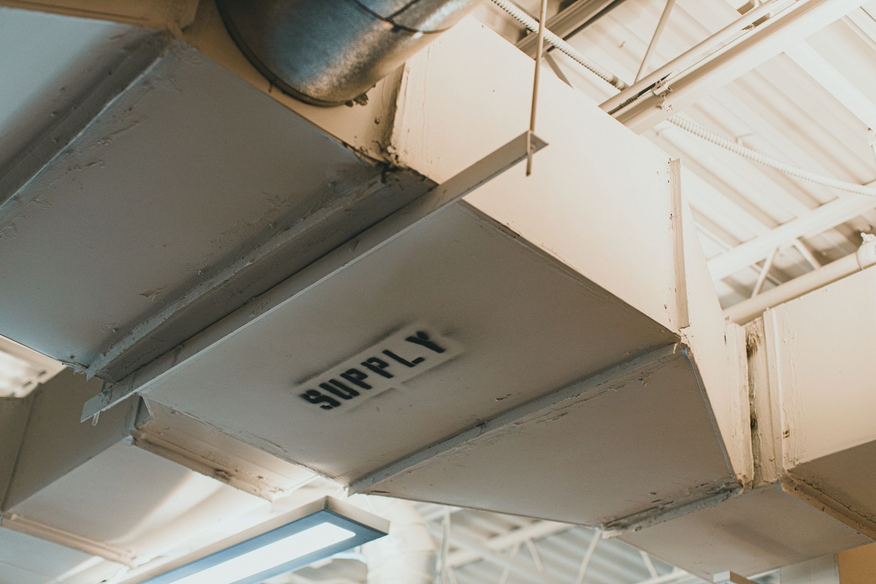 Commercial supply-air ductwork running below an open ceiling