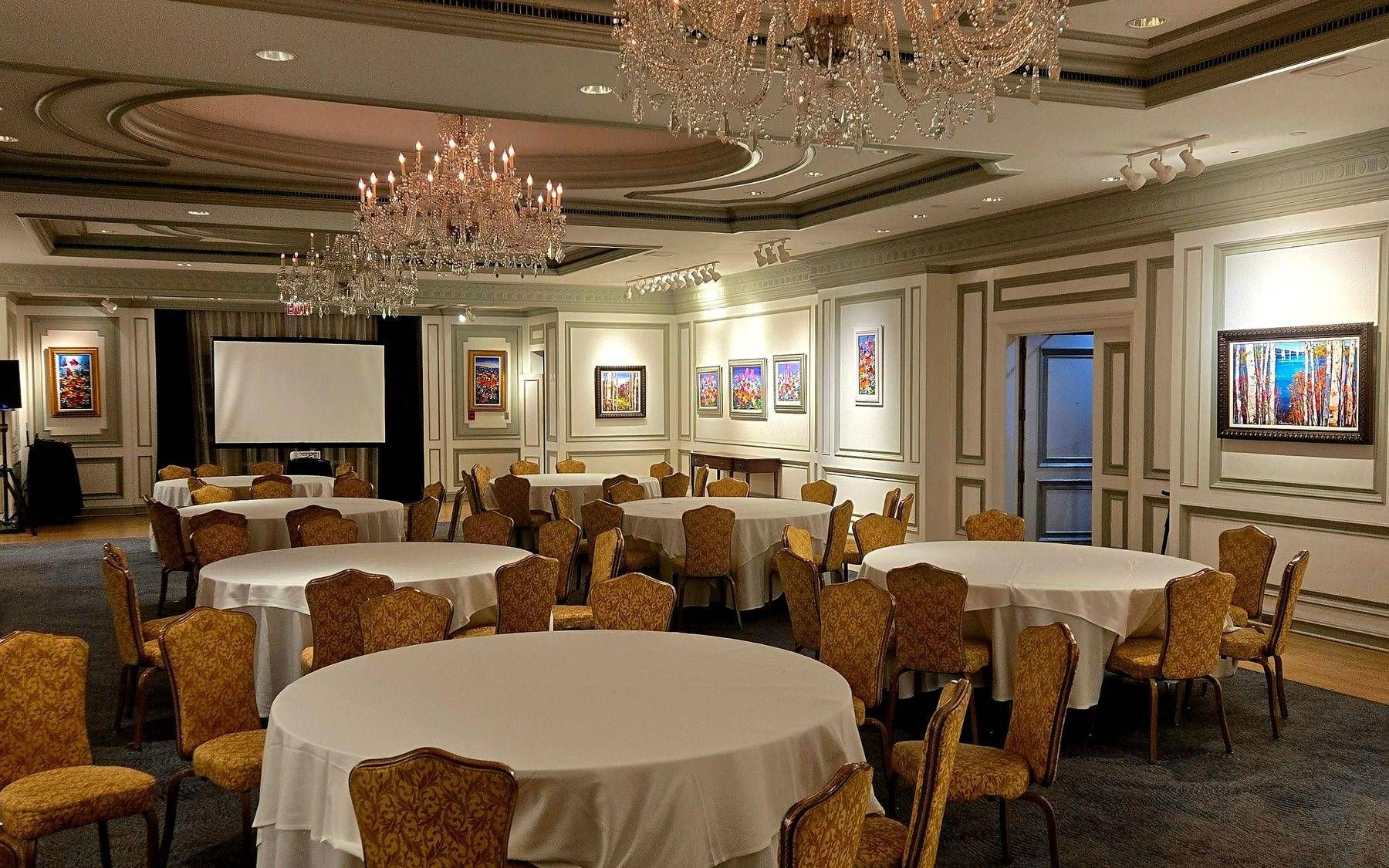 Banquet hall set with round tables and chandeliers before an event