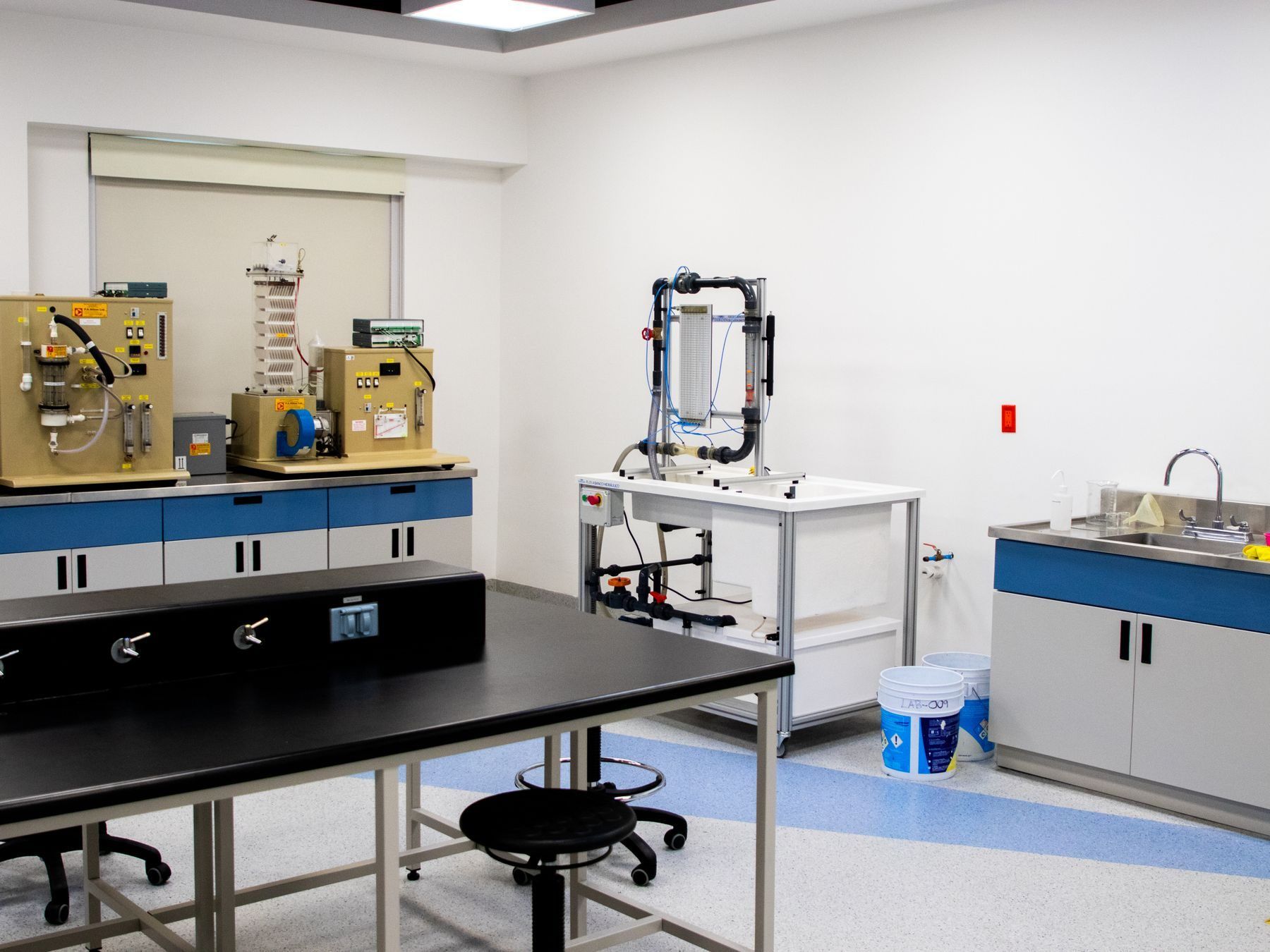 Research laboratory with lab benches, stools, a utility sink and a resilient floor