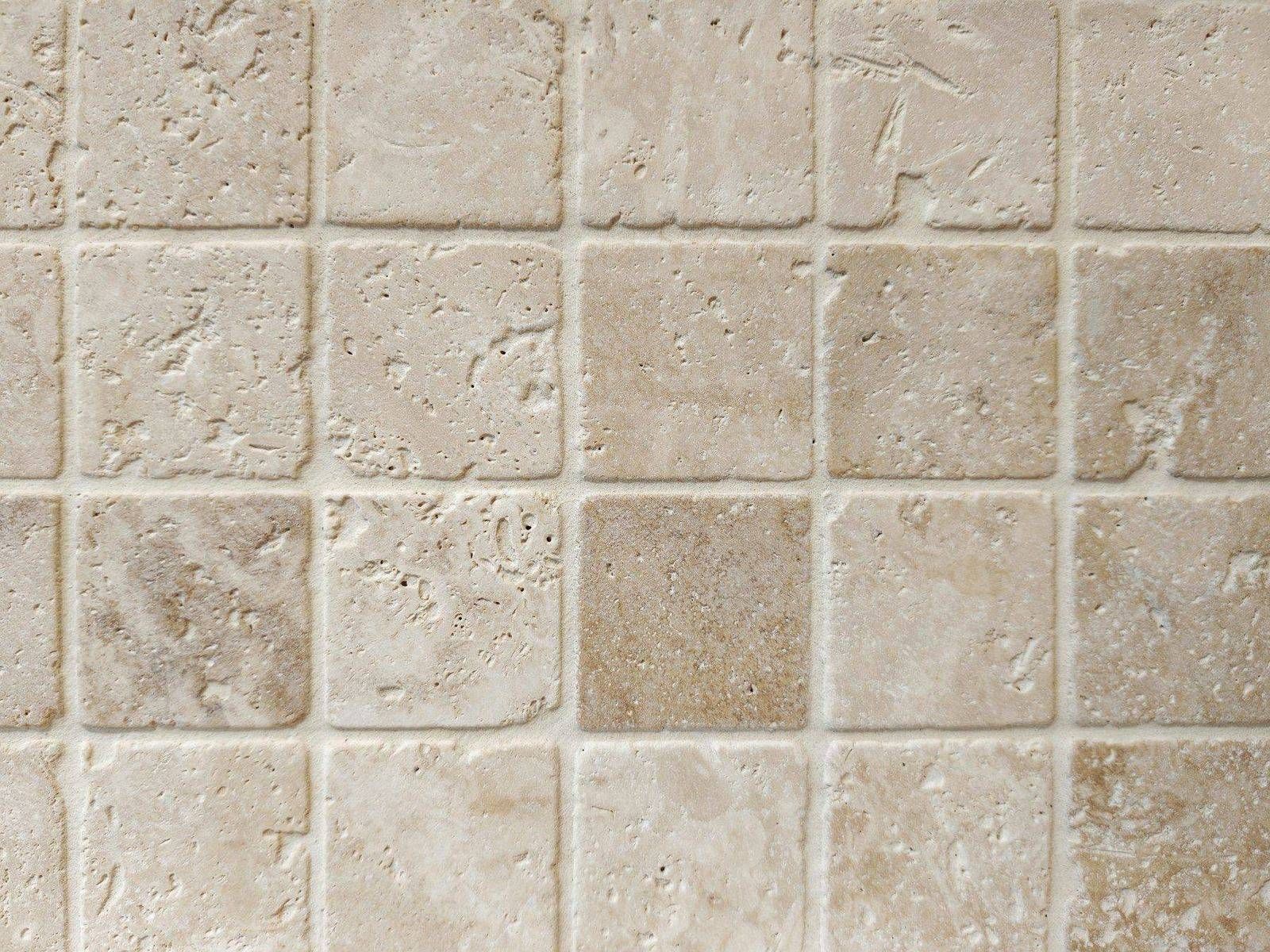 Tumbled travertine tiles with open surface voids between the grout lines