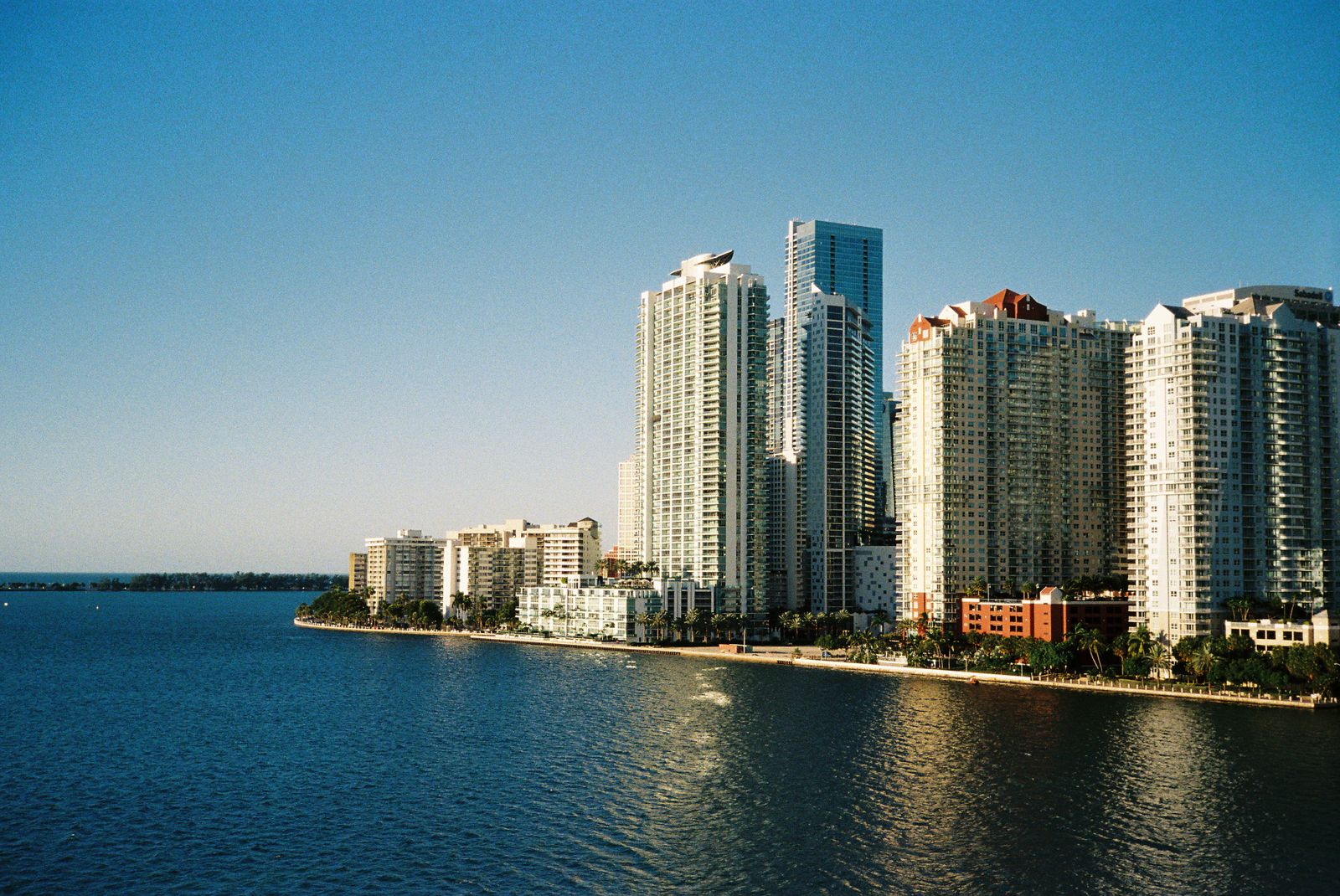 Waterfront high-rise towers under a blue sky