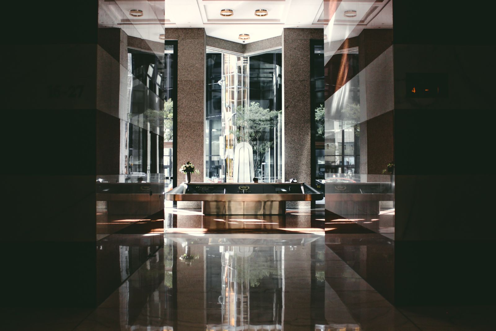 Mirror-polished stone lobby floor reflecting the building entrance
