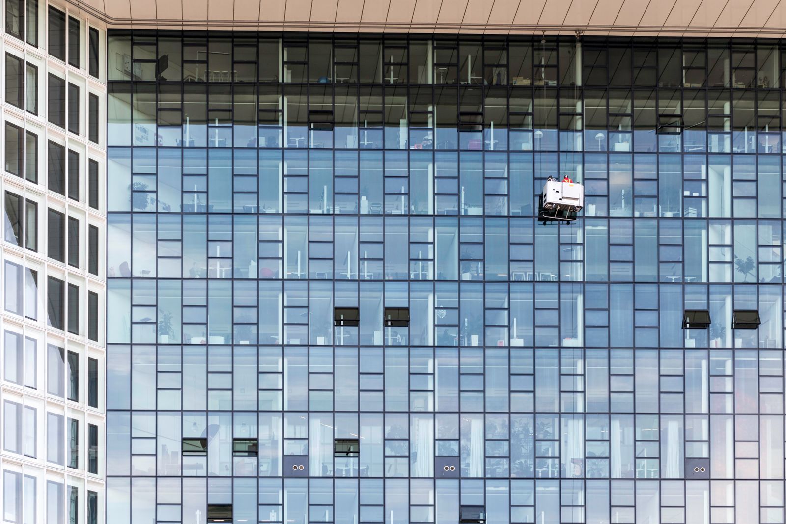 Window cleaners working on a modern commercial glass facade